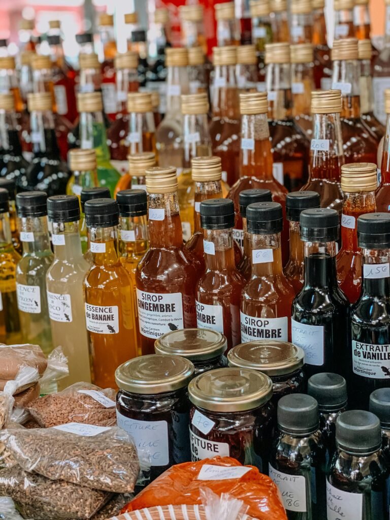 Vibrant assortment of syrups and extracts at a local Martinique market stall.